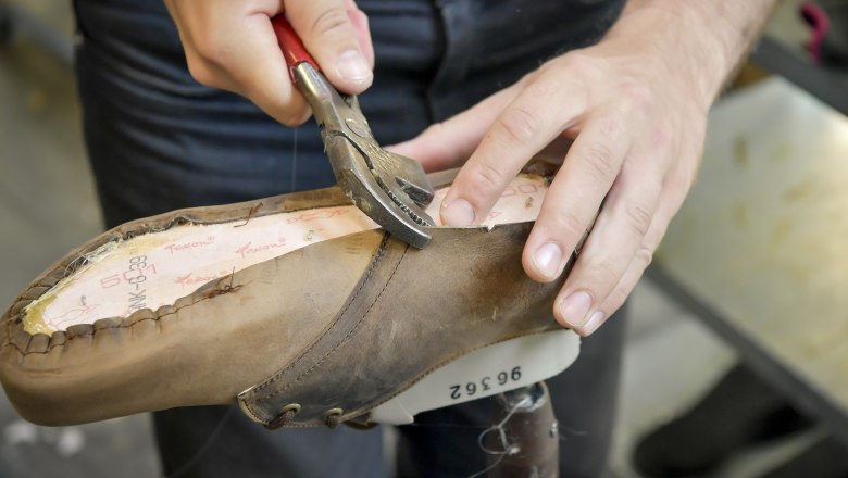 gea_01, © Waldviertel Tourismus, Robert Herbst Person bearbeitet Schuh mit Zange auf einem Leisten.
