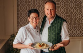 Petra und Werner Zlabinger, © Niederösterreich Werbung/Daniela Führer Ein Mann und eine Frau lächeln und halten einen Teller mit Essen.