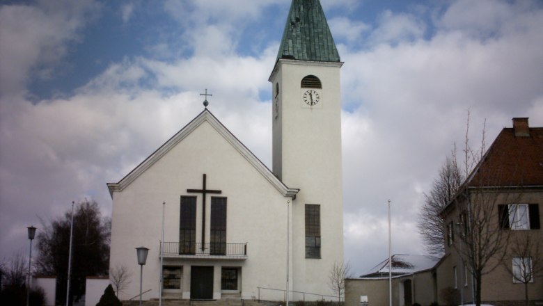 Gemeinde Sigmundsherberg, © Gemeinde Sigmundsherberg Kirche mit Turm und Uhr in Sigmundsherberg, umgeben von Schnee und Wolken.
