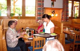 Heuriger zum Hauermandl, © Winzerfamilie Steiner Innenansicht eines traditionellen österreichischen Heurigen mit Gästen und Bedienung.