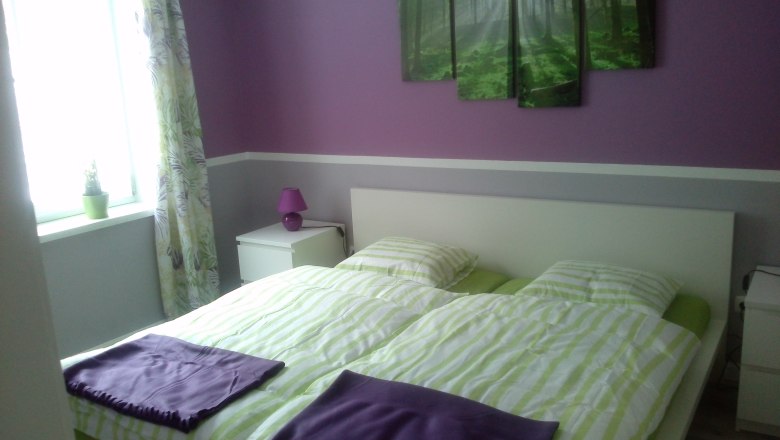 Bedroom, © Zimml Bedroom with purple and green decoration, double bed, bedside table and window.