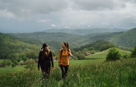 Lebensweg, Wandern, Weitwandern, © Waldviertel Tourismus, Melanie Többe Zwei Wanderer genießen die frische Bergluft und die atemberaubende Aussicht auf die sanften Hügel und dichten Wälder. Umgeben von üppigem Grün und dem sanften Rauschen des Windes, erleben sie die Freiheit und Schönheit der Natur in vollen Zügen.