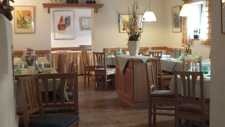 Cobane farm, © Cobaneshof Cozy restaurant with wooden furniture, laid tables and flower vases. Pictures of animals on the walls.