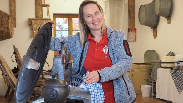 Laundry Museum, © Erlebnismuseumsverein Schönbach/Gabriele Moser A woman in a museum shows an old washing machine.