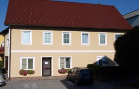 Ferienwohnungen Nöbauer, © Familie Nöbauer Gelbes zweistöckiges Haus mit rotem Dach und mehreren Fenstern.