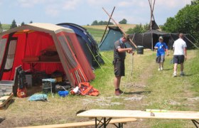 Zeltplatz Kottes, © Franz Schrammel Menschen auf einem Zeltplatz mit verschiedenen Zelten und Campingausrüstung.