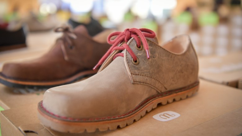 gea_03, © Waldviertel Tourismus, Robert Herbst Nahaufnahme eines braunen Lederschuhs mit roten Schnürsenkeln auf einem Karton.