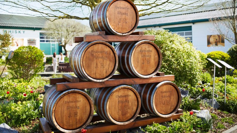 Whisky-Erlebniswelt & Destillerie Haider, © Waldviertel Tourismus, Gerhard Wasserbauer Holzfässer mit der Aufschrift 'Waldviertler Whisky J.H.' im Freien vor einem Gebäude.