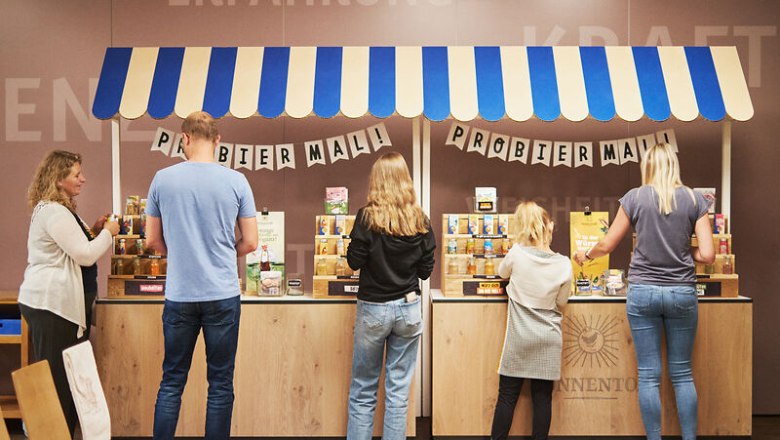 Kräuter und Gewürze probieren, © © Waldviertel Tourismus, Gerhard Wasserbauer Menschen probieren Produkte an einem Stand mit blau-weißem Dach.