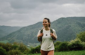 Lebensweg, Wandern, Weitwandern, © Waldviertel Tourismus, Melanie Többe Ein Wanderer genießt die frische Bergluft und die atemberaubende Aussicht auf die sanften Hügel und dichten Wälder. Die Wolken am Himmel verleihen der Szenerie eine mystische Atmosphäre, während die Natur in voller Blüte steht. Diese Idylle lädt dazu ein, die Seele baumeln zu lassen und die Schönheit der Umgebung zu erkunden.