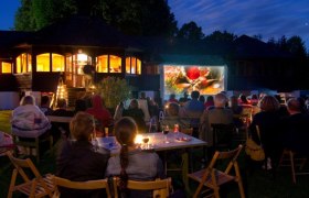 Filmclub Drosendorf, © Filmclub Drosendorf Menschen schauen im Freien einen Film auf einer Leinwand an.