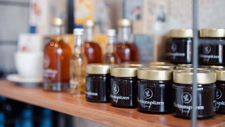 Produkte im Shop Taflerei, © Hotel Schachner_MIKU Media Regal mit Gläsern und Flaschen im Laden Taflerei.