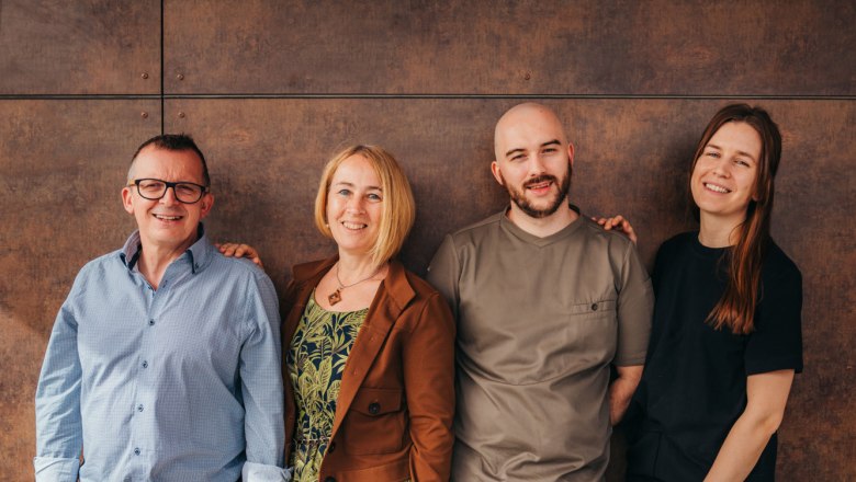 Familie Thaler, © Niederösterreich Werbung/Daniela Führer Vier Personen stehen lächelnd nebeneinander vor einer braunen Wand.