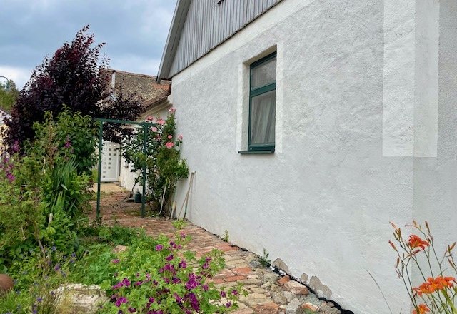 Exterior view, © Julia Grünschachner Exterior view of a house with a white wall, garden and flowers.