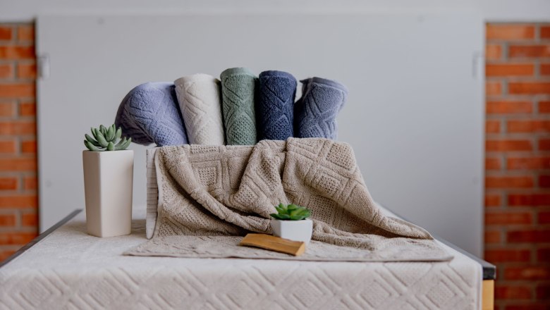 Framsohn Frottier, © Waldviertel Tourismus, Matthias Streibel Farbige Handtücher und Pflanzen auf einem Tisch vor einer Ziegelwand.