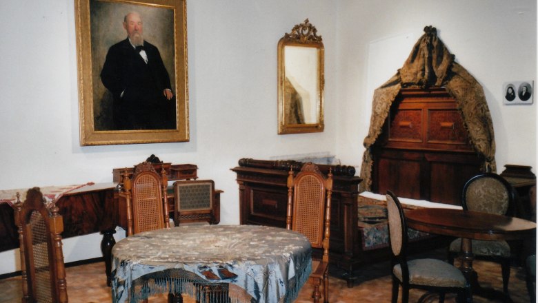 Time Bridge Museum, © Zeitbrücke-Museum Historic room with antique furniture and a painting of a man on the wall.