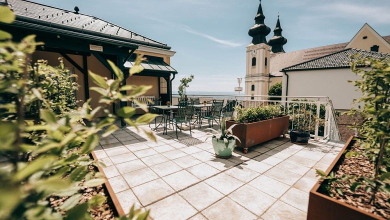 Zum Goldenen Löwen, © Zum Goldenen Löwen Terrasse mit Blick auf eine Kirche mit Zwiebeltürmen.