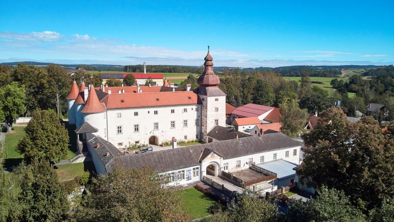 Schloss Dobersberg, © Waldviertel Tourismus, lichtstark.com Luftaufnahme von Schloss Dobersberg mit rotem Dach und umliegender Landschaft.
