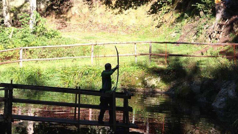 BogensportWaldviertelDorfstetten, © KLammer Walter Person mit Bogen auf einer Brücke im Wald.