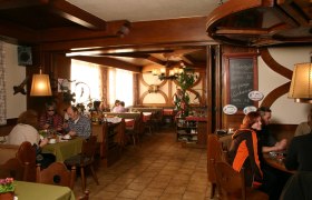 die gemütlichen Stuben, © Marschall stuben Gemütliches Restaurant mit Holzmöbeln und Gästen an Tischen.
