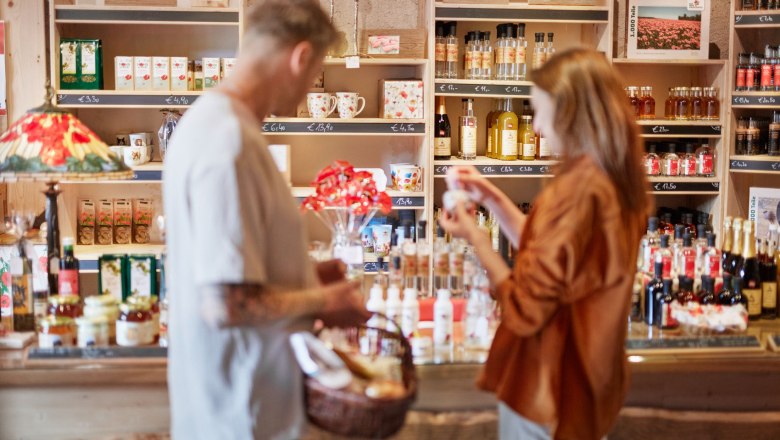 Mohnbauernladen, © © Waldviertel Tourismus, Gerhard Wasserbauer Zwei Personen in einem Laden mit Regalen voller Produkte und Dekorationen mit Mohn.