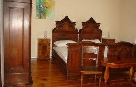 Jakob-Kern Gästehaus, © Jakob-Kern Gästehaus Ein traditionell eingerichtetes Schlafzimmer mit antiken Holzmöbeln, darunter zwei Betten, ein Schrank und ein Tisch.