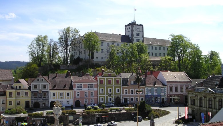 Weitra, © Karin Pollak, NÖN Blick auf den Hauptplatz von Weitra mit bunten Häusern und einem Schloss im Hintergrund.