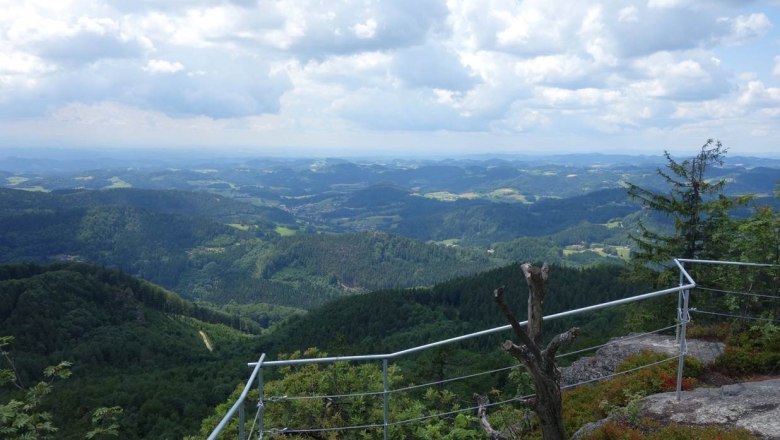 Aussichtsberg Burgsteinmauer, © Leo Baumberger Aussicht von der Burgsteinmauer über bewaldete Hügel und Täler unter einem bewölkten Himmel.