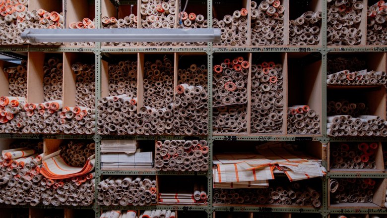 Lochkarten, © Waldviertel Tourismus, Matthias Streibel Regal mit vielen gerollten Papierdokumenten in Fächern.