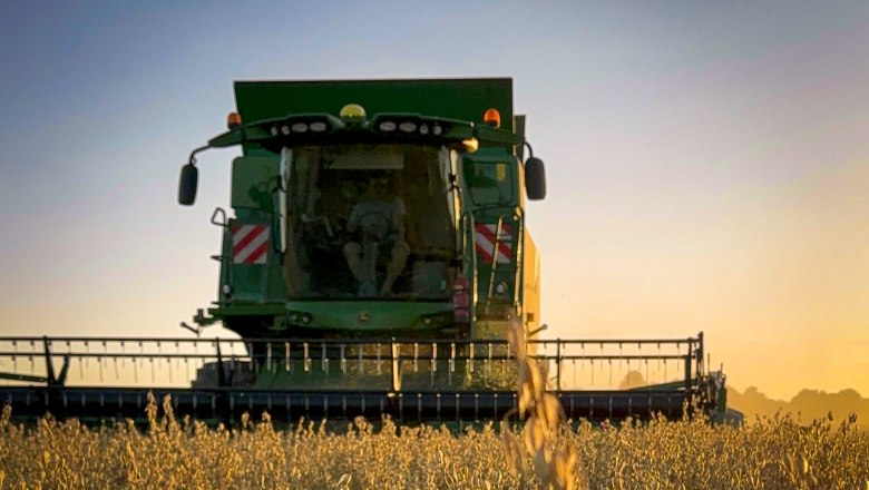 Farm-gate sale Haidl family, © Familie Haidl A combine harvester harvests a field at sunset.