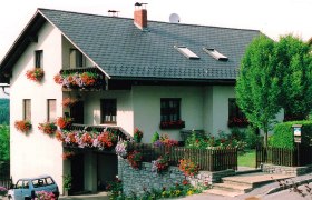 Ferienwohnung Pfeiffer-Vogl, © Ferienwohnung Pfeiffer-Vogl Ein zweistöckiges Haus mit Blumen geschmückten Balkonen und einem kleinen Garten.