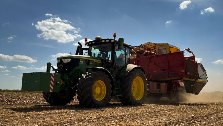 Farm-gate sale Haidl family, © Familie Haidl A tractor with a trailer drives across a harvested field under a blue sky with a few clouds.