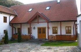 Heurigen-Gasthof Prinz, © Dieter Prinz Ein traditionelles Gebäude mit rotem Ziegeldach und Holzelementen, umgeben von einem gepflasterten Hof.