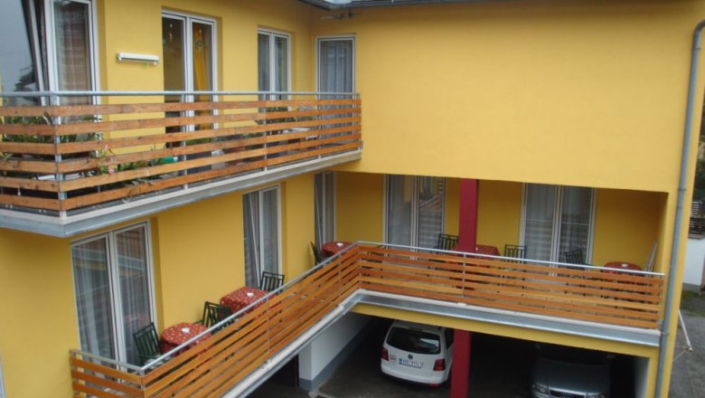 Frühstückspension Reinhard Todt, © Reinhard Todt Gelbes Gebäude mit Balkonen und geparkten Autos darunter.