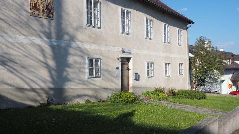 Pfarrhof, © MG Sallingberg Ein zweistöckiges Gebäude mit mehreren Fenstern und einem Schild über der Tür, umgeben von einem gepflegten Garten.