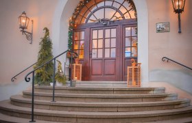 Eingang, © Schlossschenke Eingang mit dekorierten Weihnachtsbäumen und Lichtern.