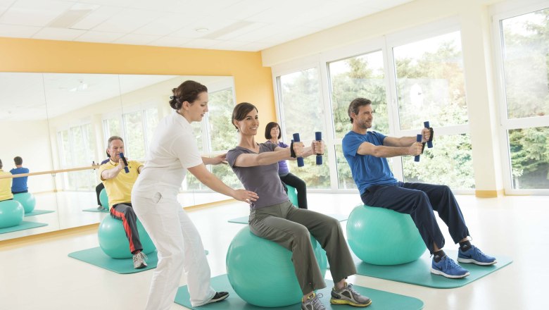 Heilgymnastik, © Xundheitswelt Menschen bei der Heilgymnastik auf Gymnastikbällen mit Hanteln.