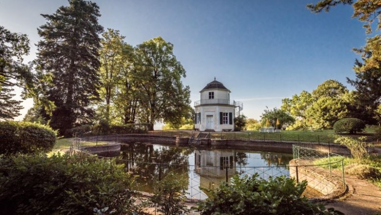 Bathing pavilion, © Schloss Artstetten/D. Mayrhofer A round pavilion stands on the banks of a small pond, surrounded by trees and a well-tended garden.