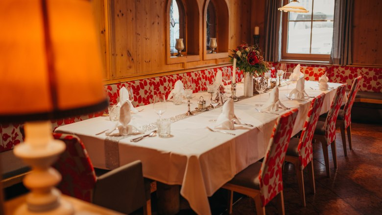 Elegantes aber dennoch gemütliches Gastzimmer, © Niederösterreich Werbung/Daniela Führer Elegantes Gastzimmer mit gedecktem Tisch, Holzverkleidung und Blumenarrangement.