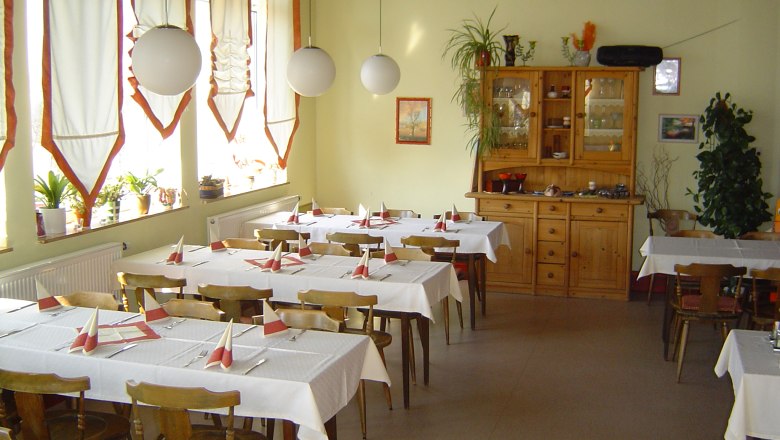 Cafe Maria, © Cafe Maria Innenansicht eines gemütlichen Cafés mit Holzmöbeln und dekorierten Tischen.