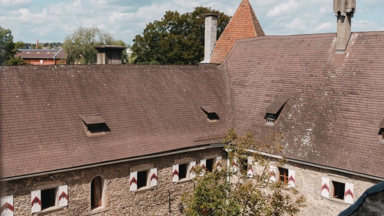 Burg Heidenreichstein, © Waldviertel Tourismus, Line Sulzbacher Innenhof der Burg Heidenreichstein mit Steinmauern und Ziegeldach unter blauem Himmel.