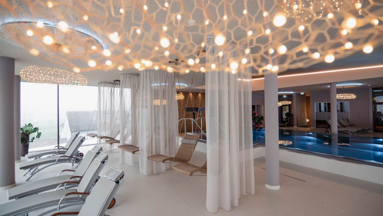 Ruhebereich im WACHAUF Spa, © Hotel Schachner_MIKU Media Moderner Spa-Ruhebereich mit Liegestühlen, Hängesesseln und Pool.