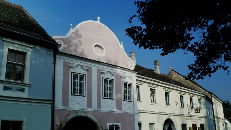 Gemeinde Hadersdorf-Kammern, © Gemeinde Hadersdorf-Kammern Historische Gebäude in Hadersdorf-Kammern mit blauer und rosa Fassade.