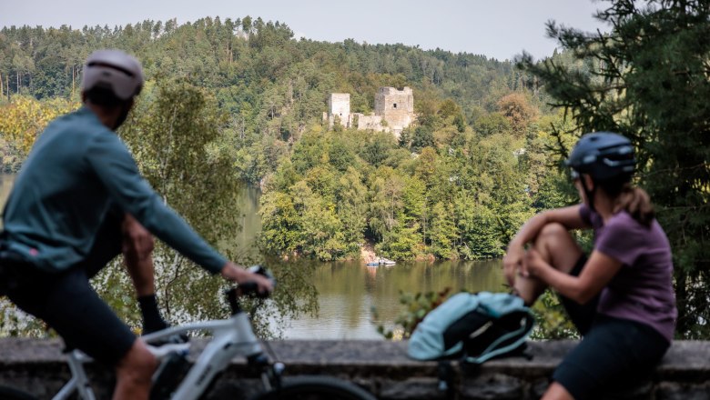 Kamptal Radweg, Stausee Dobra, © Erwin Haiden Zwei Radfahrer betrachten die Ruine Dobra über einen See.