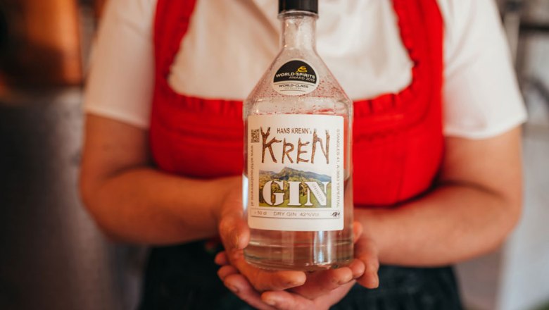 Internationally award-winning brandies, © Niederösterreich Werbung/Daniela Führer Person holding a bottle of Krenn gin with a label.