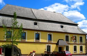 Gasthaus Fichtinger, © Marktgemeinde Bad Traunstein Gelbes Gasthaus mit grauem Dach und rotem Auto davor.