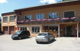 Gasthaus Spatschek, © Gasthaus Spatschek Gasthaus mit Balkon und Blumen, zwei geparkte Autos davor.