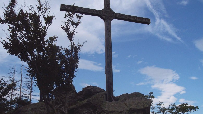 Peilstein, © Gemeinde Münichreith-Laimbach Ein Gipfelkreuz auf einem Felsen mit blauem Himmel im Hintergrund.