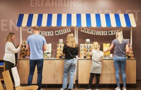 Kräuter und Gewürze probieren, © © Waldviertel Tourismus, Gerhard Wasserbauer Menschen probieren Produkte an einem Stand mit blau-weißem Dach.