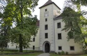 Kleine Eibe, © Wager Historisches Gebäude mit Turm und Bäumen im Vordergrund.